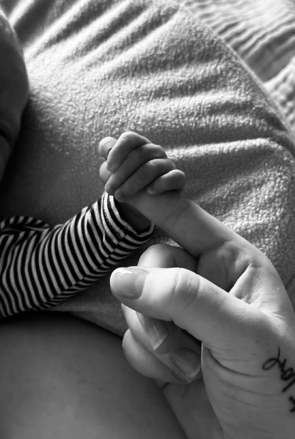Hudson's hand holding Tia's finger